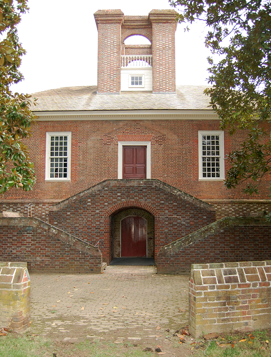 large brick house with symmetrical brick stairs in front