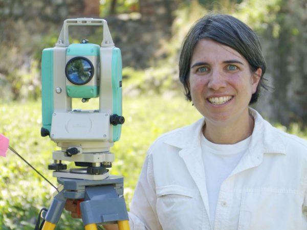 Woman standing next to a total station