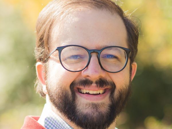 Man with glasses posed outdoors