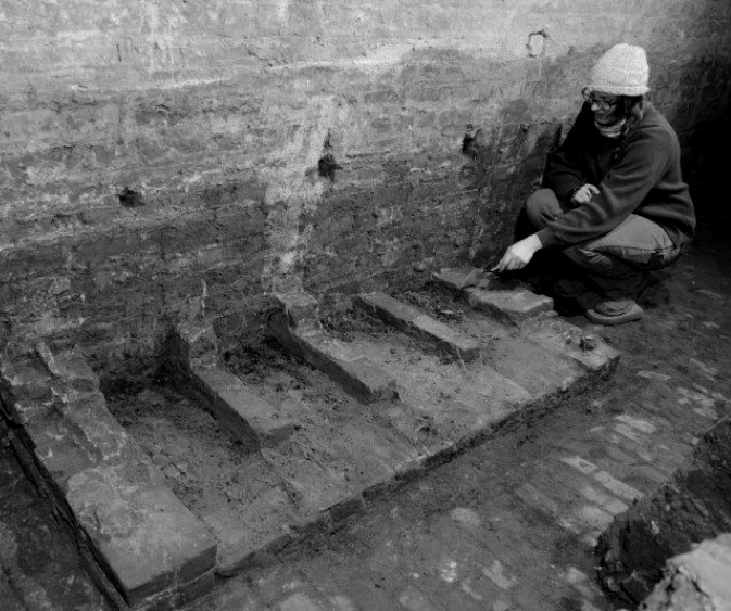 archeologist working on a brick wall