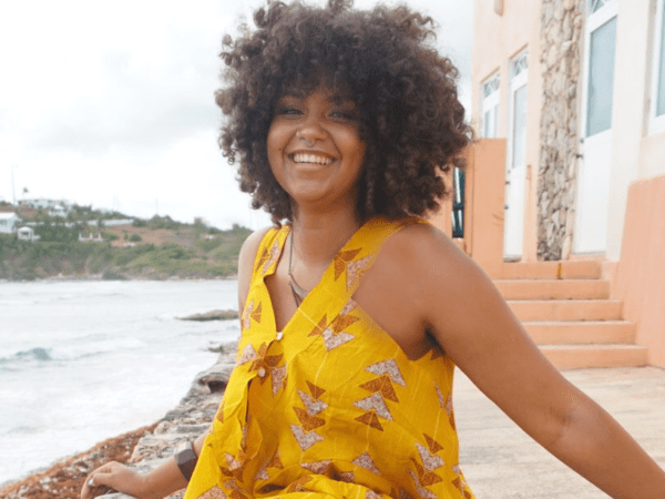 Woman with yellow dress posed in front of a body of water