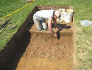 Pogue’s 2013 excavations revealed the same brick features recorded by Williams in 1932, which Williams suggested as a “drainage feature.” Pogue’s work concluded these features were planting beds. Here an excavator removes the last vestiges of overlying fill soils to expose the planting bed feature in Pogue’s unit 545. Photo Credit: Dennis Pogue (2013).