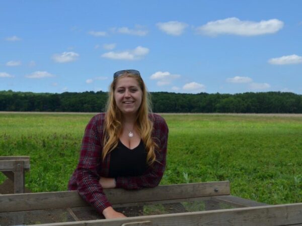 Woman posed with an artifact screen in a field