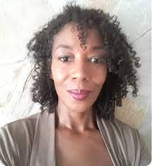 Woman with curly hair, with a neutral backdrop