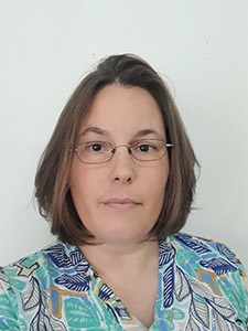 Woman with a botanical printed top, with a neutral backdrop