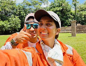 Two people wearing orange fieldwork suits, taken outdoors